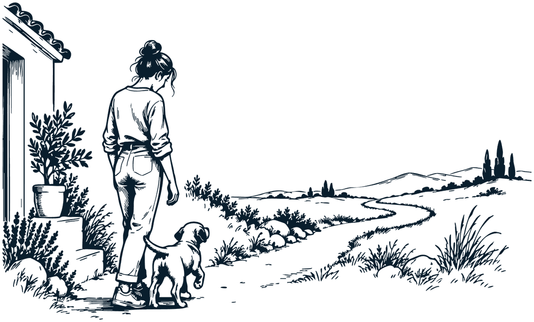 A woman walking a small dog along a country path away from her house